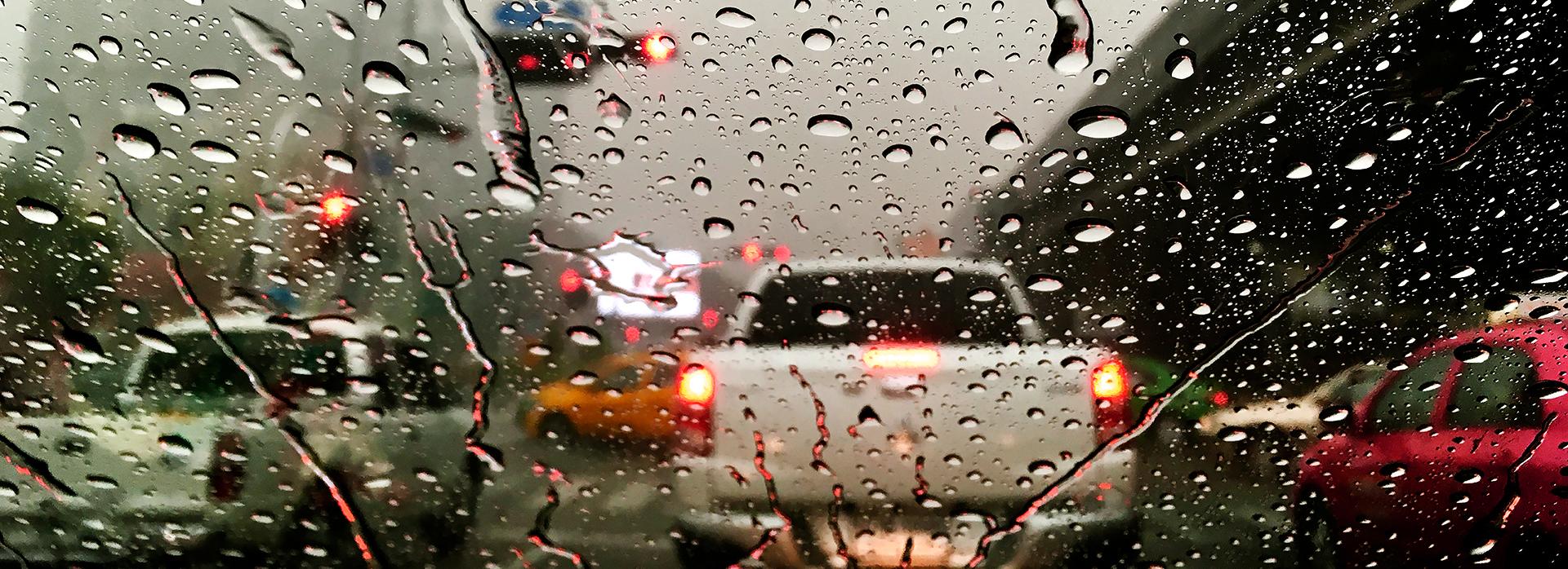 Rain covered windshield in traffic. 